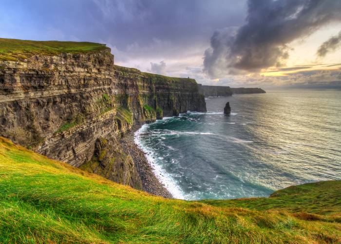 Falaises de Moher surplombant l'océan Atlantique dans le comté de Clare. Impressionnantes parois rocheuses s'élevant à plus de 200 mètres au-dessus des vagues, offrant une vue panoramique spectaculaire sur la côte sauvage irlandaise