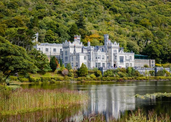 Kylemore Abbey, château néogothique majestueux, se reflétant dans les eaux calmes du lac Pollacapall dans le Connemara, comté de Galway, Irlande. Bâtiment qui incarne l'élégance victorienne