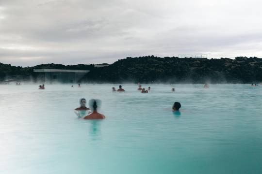 Baignade relaxante dans les eaux laiteuses du Blue Lagoon en Islande, une étape bien-être à ne pas manquer lors d’un road trip en van avec Avis Explore