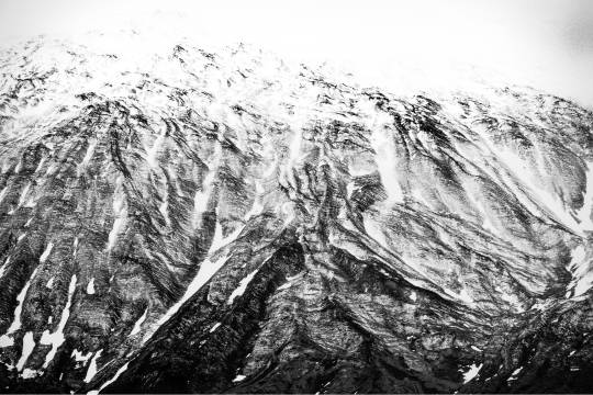 Reliefs montagneux du glacier Snæfellsjökull enneigés en Islande, décor dramatique en noir et blanc idéal pour une aventure hivernale extrême avec Avis Explore