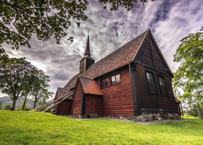 Église en bois debout de Kvernes, unique stavkirke norvégienne post-médiévale, surplombant le fjord avec ses poutres de soutien caractéristiques