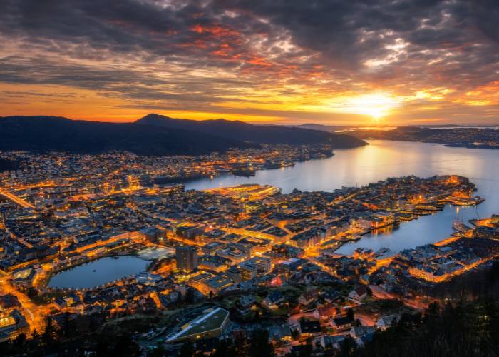 Soleil de minuit illuminant le ciel au-dessus de Bergen, Norvège, créant une ambiance magique et unique pendant les longues nuits d'été