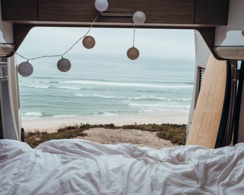 Vue imprenable sur l’océan depuis un lit en van, réveil face à la mer avec AVIS Explore