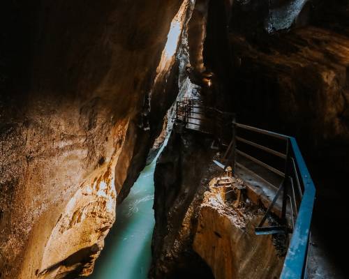 Passerelle accessible traversant les gorges de l'Aar en Suisse, entourée de parois rocheuses imposantes et située dans la région montagneuse de l'Oberland bernois